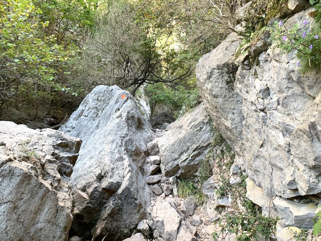 Puntito rojo en roca marcando camino en Els Empedrats